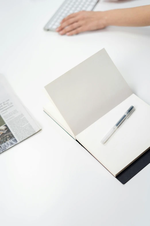 a person sitting at a desk with a keyboard and a notebook, a drawing, private press, white space in middle, fountain pen, thumbnail, sustainable materials