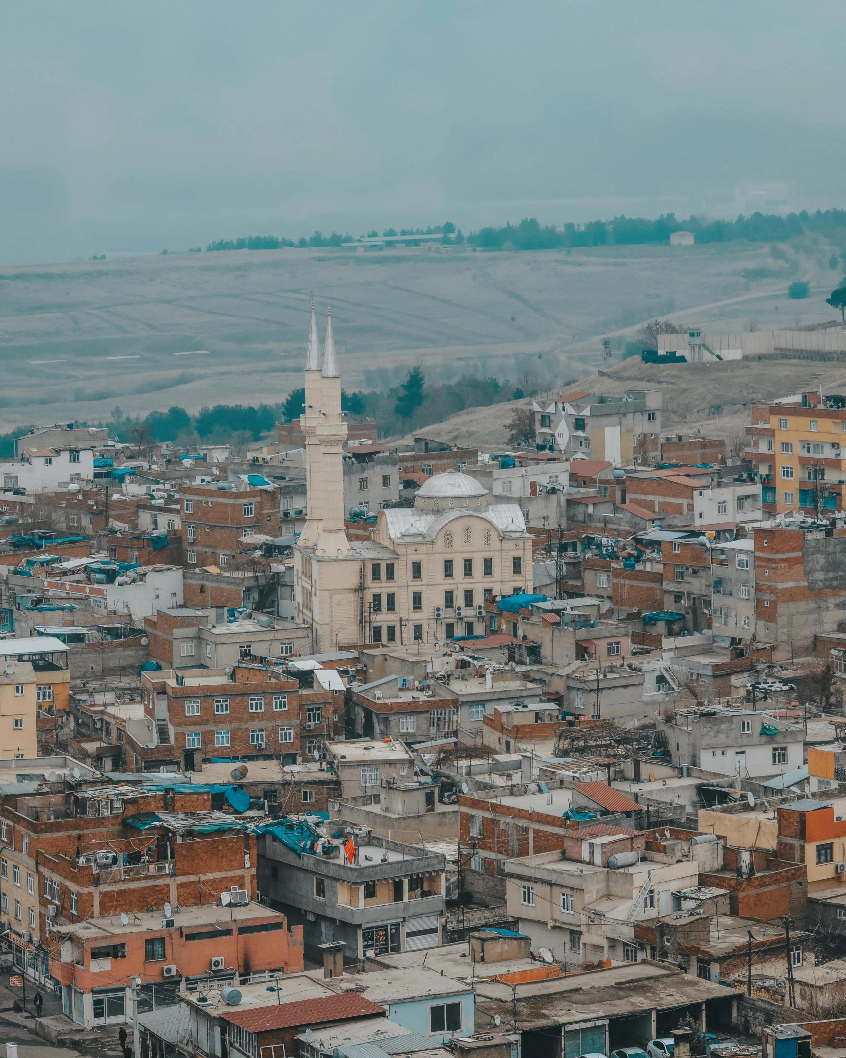 a view of a city from the top of a hill, an album cover, by Ismail Acar, trending on unsplash, hurufiyya, preserved historical, muslim, lebanon kirsten dunst, grey