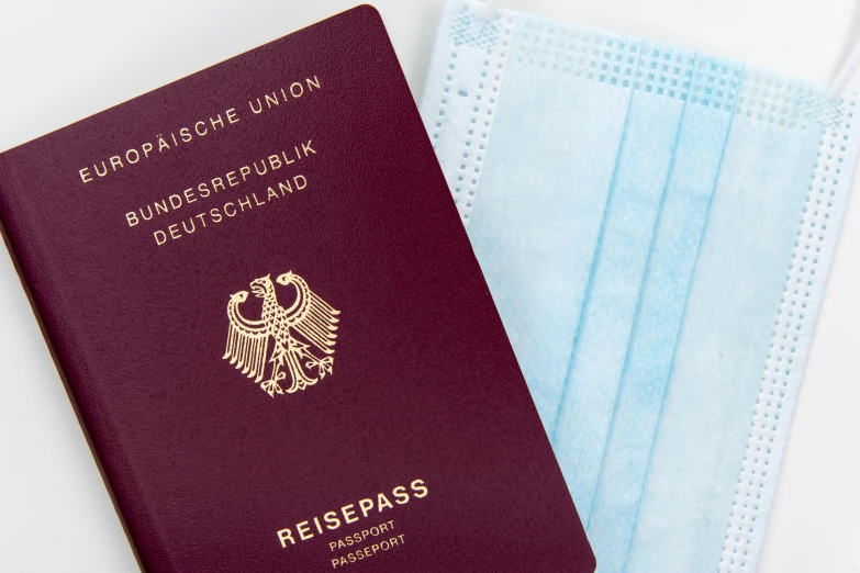 a passport and a face mask sitting next to each other, by Kristian Zahrtmann, pexels, private press, german chancellor, game ready, thumbnail, dezeen