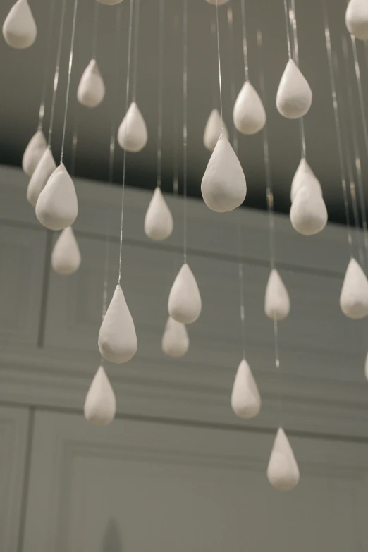 a bunch of white raindrops hanging from a ceiling, inspired by Lucio Fontana, white clay, medium closeup, made of marble, 2 0 1 0 s