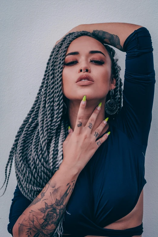 a woman with dreadlocks posing for a picture, inspired by Elsa Bleda, trending on pexels, vanessa morgan, in gunmetal grey, twisted braid, vibrant high contrast