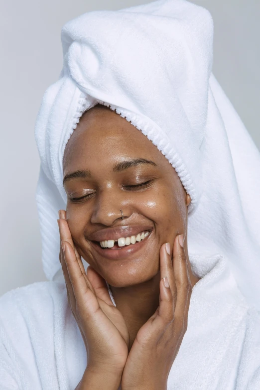 a woman with a towel wrapped around her head, by Matija Jama, trending on pexels, renaissance, happy facial expression, silicone skin, glossy surface, front facing