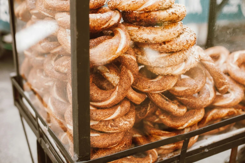 a cart filled with lots of doughnuts on top of a street, a portrait, by Emma Andijewska, trending on pexels, hurufiyya, bagels, golden hour closeup photo, orthodox, thumbnail