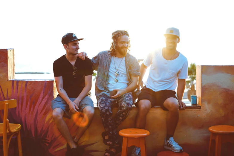 a group of young men sitting next to each other, a portrait, by Tom Bonson, pexels contest winner, sunflare, band promo, palms, aussie baristas