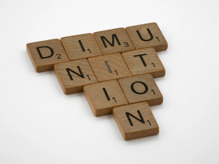 wooden scrabbles spelling dimu nition on a white surface, by Simon Marmion, unsplash, abomination, da vinci, badminton, mining