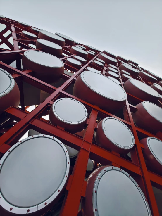 a tall red building with lots of round windows, inspired by Alexander Rodchenko, unsplash, kinetic art, close-up shot from behind, shipping containers, drooling ferrofluid, huge speakers