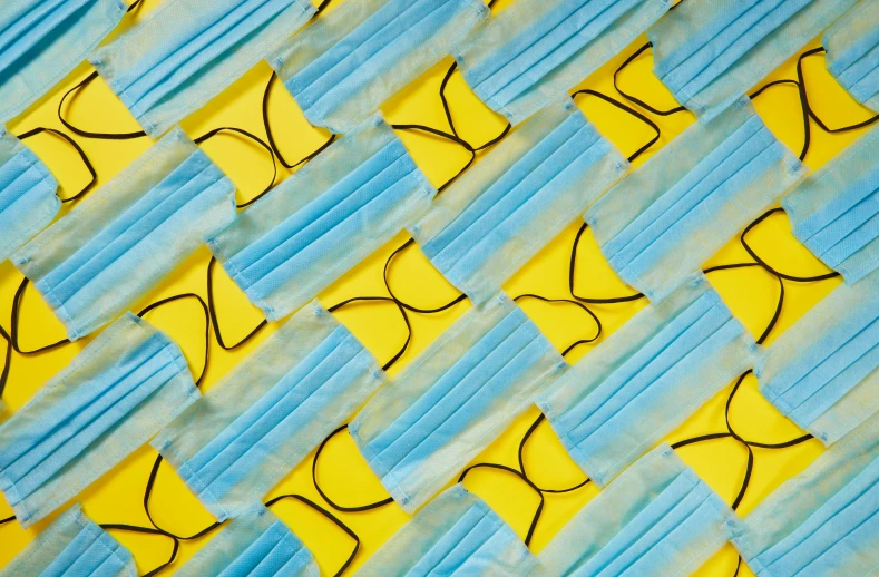 a close up of a piece of paper with glasses on it, by Carey Morris, conceptual art, blue and yellow ribbons, repeating fabric pattern, surgical mask covering mouth, thumbnail