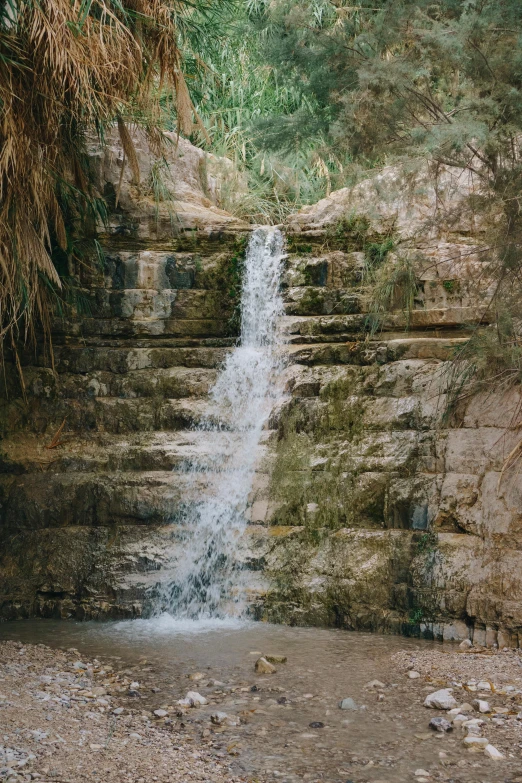 a man standing in front of a waterfall, les nabis, secret valley, erosion channels river, steps, splashing