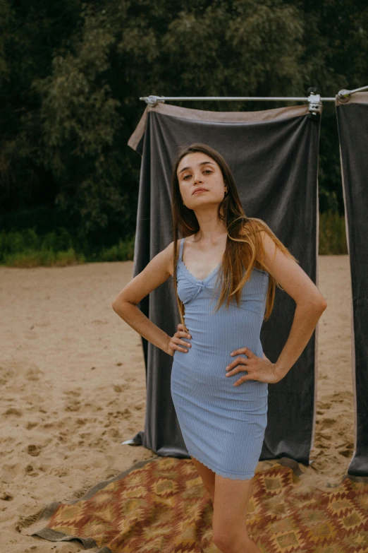 a beautiful young woman standing on top of a beach, an album cover, by Attila Meszlenyi, wearing a blue dress, portrait featured on unsplash, blue undergarments, blue and grey