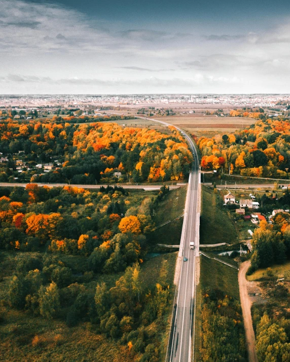 an aerial view of a highway surrounded by trees, by Anato Finnstark, city of pristine colors, lgbtq, countryside city scene, ultrawide landscape