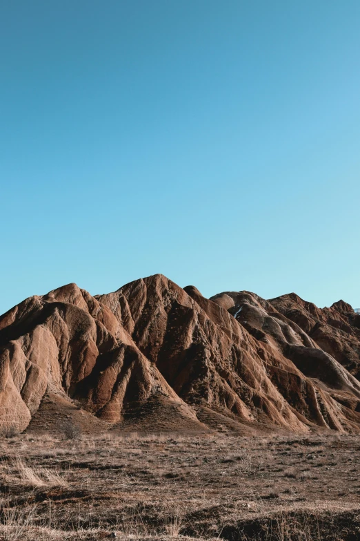 a man riding a motorcycle down a dirt road, an album cover, trending on unsplash, visual art, chiseled formations, baotou china, landslides, blue skies