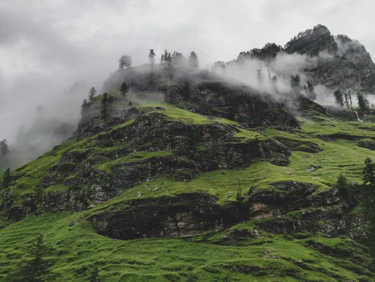 a mountain covered in green grass and trees, pexels contest winner, hurufiyya, monsoon, grey, multiple stories, completely empty