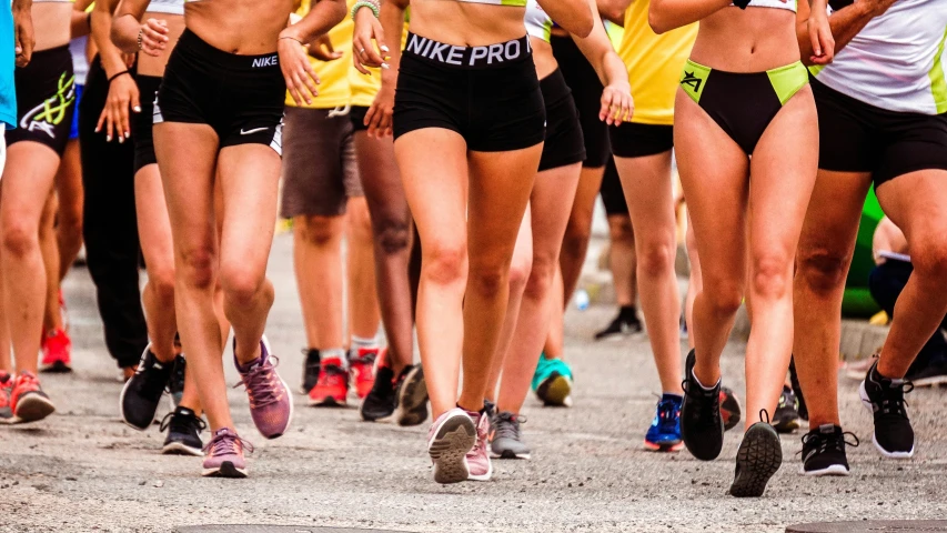 a group of women running in a marathon, antipodeans, thigh gap, nike logo, 2019 trending photo, bra and shorts streetwear