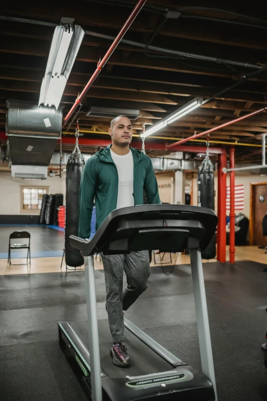 a man running on a treadmill in a gym, a portrait, featured on reddit, wearing a hoodie and sweatpants, boston, color corrected, gif