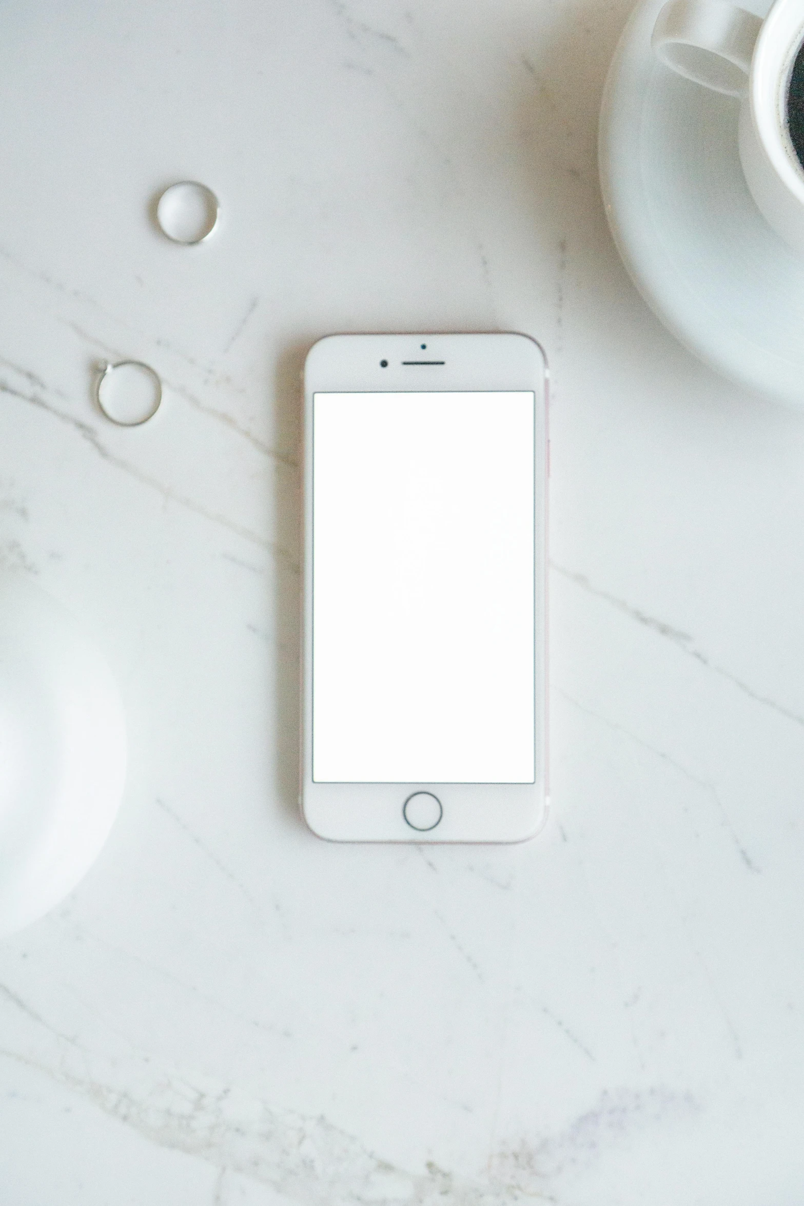 a cell phone sitting on top of a table next to a cup of coffee, trending on pexels, minimalism, white marble and gold, all white, ios app icon, square