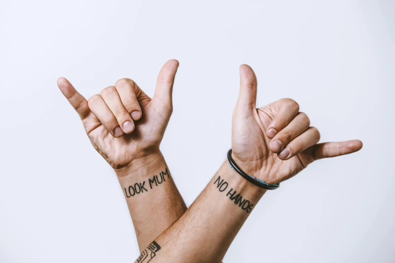 a couple of people that have tattoos on their arms, by Nina Hamnett, trending on pexels, antipodeans, giving the thumbs up, on clear background, two male, background image