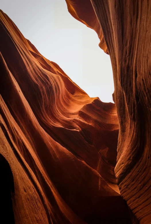 a close up of a rock formation with a sky in the background, antelope canyon, slide show, river flowing through a wall, tubes