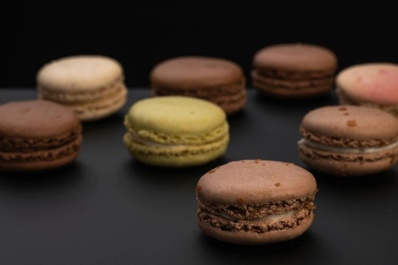 a bunch of macarons sitting on top of a table, dark earthy colours, detailed product image, ground - level medium shot, murata range