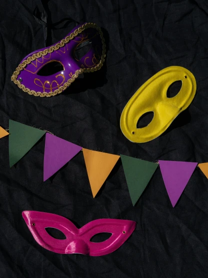 a couple of masks sitting on top of a bed, inspired by Bernd Fasching, trending on unsplash, yellow purple green black, red pennants, thumbnail, cinematic outfit photo