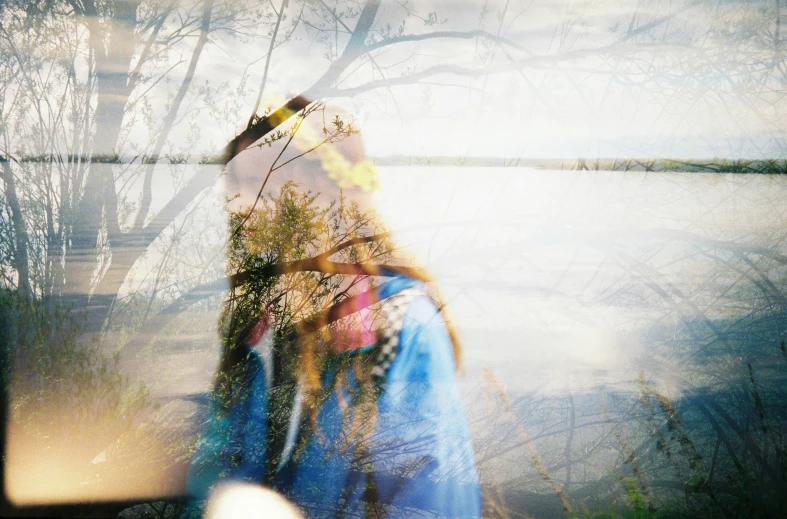 a woman standing in front of a body of water, by Maria van Oosterwijk, unsplash, process art, photographed on damaged film, psychedelic shaman, blurred face, nature outside