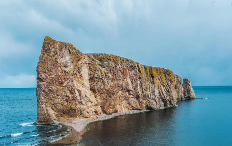 a large rock in the middle of a body of water, by Adam Marczyński, pexels contest winner, les nabis, coastal cliffs, thumbnail, readhead, nina tryggvadottir