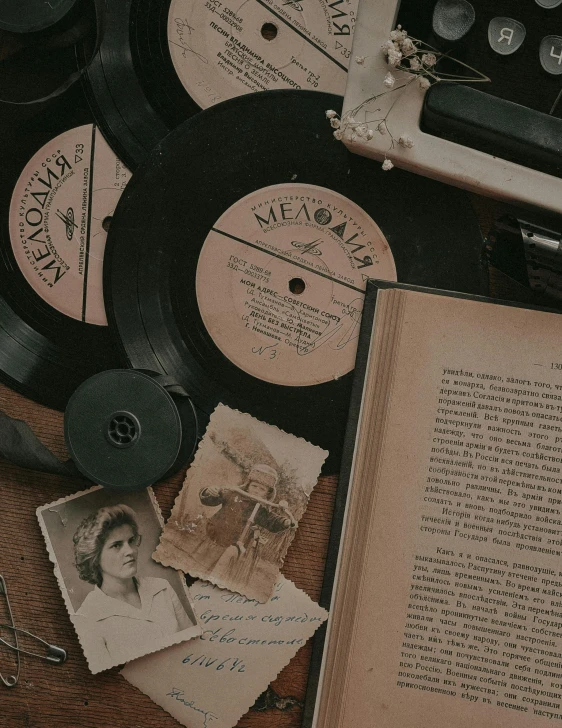 an open book sitting on top of a wooden table, an album cover, by Lucia Peka, pexels contest winner, 1940s photo, performing, various items, still from a movie