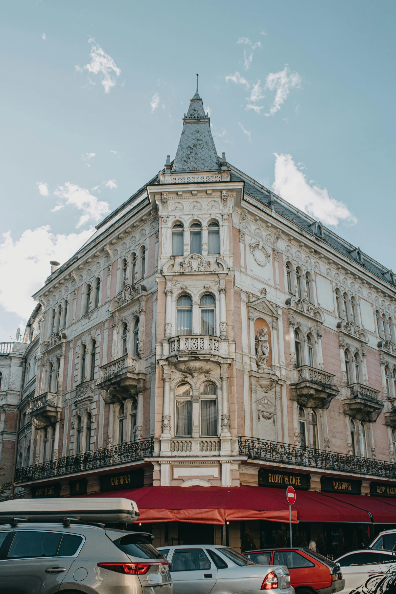 a group of cars driving down a street next to tall buildings, inspired by Mihály Munkácsy, pexels contest winner, art nouveau, lviv historic centre, exterior view, freddy mamani silvestre facade, square