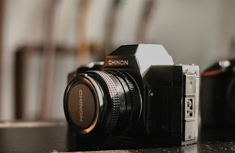 a close up of a camera on a table, by Niko Henrichon, unsplash contest winner, photorealism, 1980s photography, medium format. soft light, home video footage, shot on nicon camera