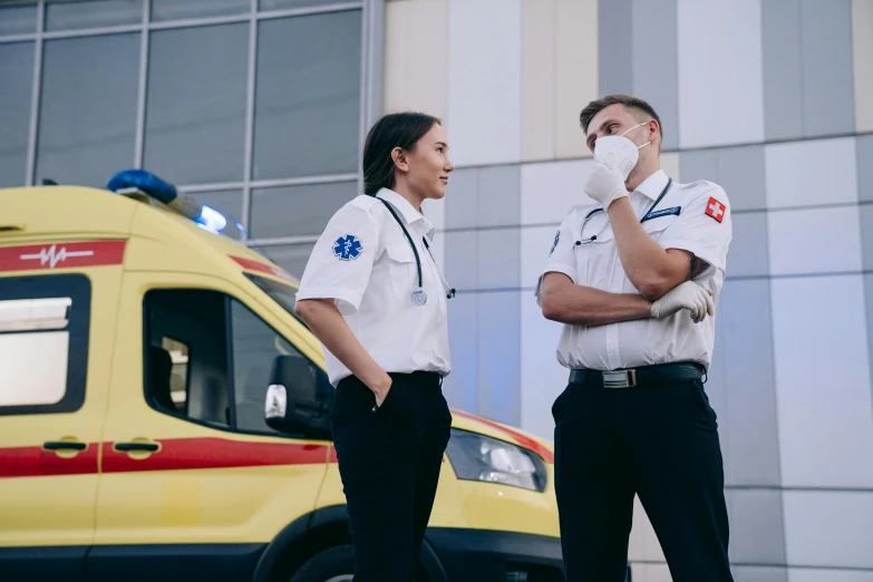 a couple of people standing next to an ambulance, pexels contest winner, symbolism, profile image, scrubs, caucasian, facing left