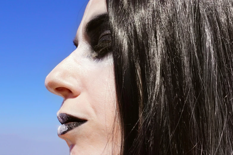 a close up of a person with makeup on, an album cover, inspired by Bálint Kiss, unsplash, goth asthetics, on a sunny day, transgender, looking to the sky