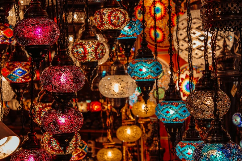 a room filled with lots of different colored lamps, a mosaic, by Julia Pishtar, trending on pexels, arabian nights, red lanterns, with lots of glittering light, magical village