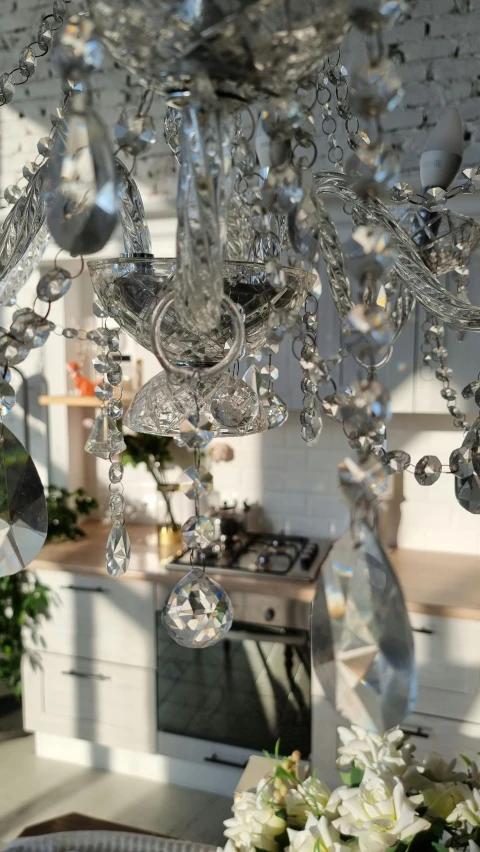 a living room filled with furniture and a chandelier, inspired by Cerith Wyn Evans, pexels, crystal cubism, detail shot, house kitchen on a sunny day, grey, taken with canon 5d mk4