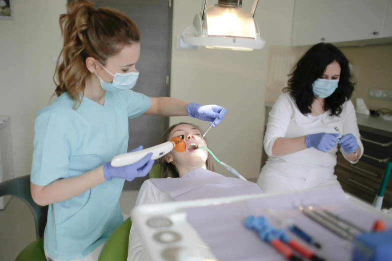 a woman getting her teeth examined by a dentist, by Adam Marczyński, pexels contest winner, hurufiyya, with electric arc devices, avatar image, group photo, pristine and clean