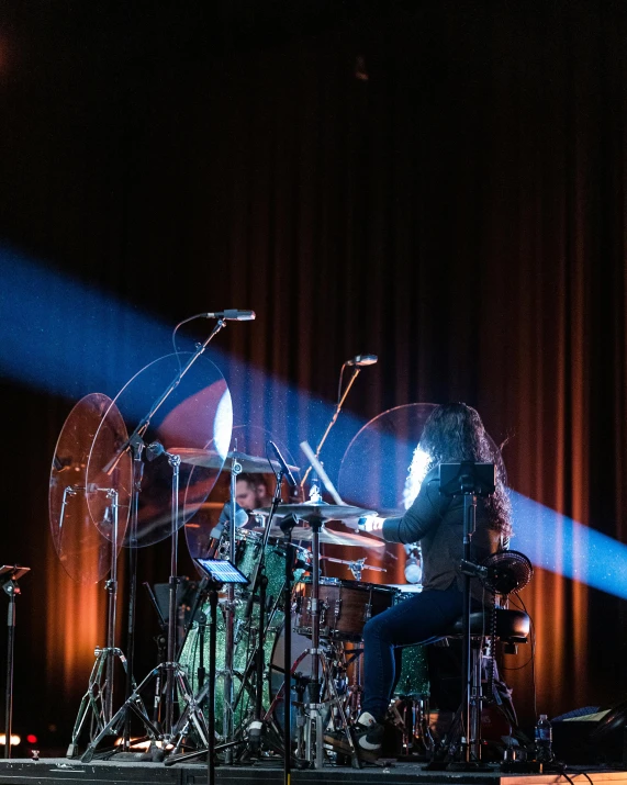 a man that is sitting in front of a piano, playing drums, ( ( stage lights ) ), david shing, lachlan bailey