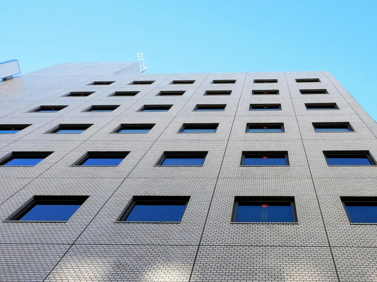 a very tall building with lots of windows, inspired by Tadao Ando, unsplash, minimalism, square shapes, low-angle, window ( city ), arasaka