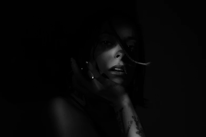 a woman smoking a cigarette in the dark, a black and white photo, by Emma Andijewska, pexels contest winner, minimalism, charli xcx, arca album cover, tattooed, black woman