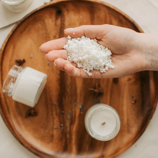 a person holding a handful of sea salt in their hand, pexels, process art, vegetables on table and candle, on a wooden tray, photoshoot for skincare brand, rice