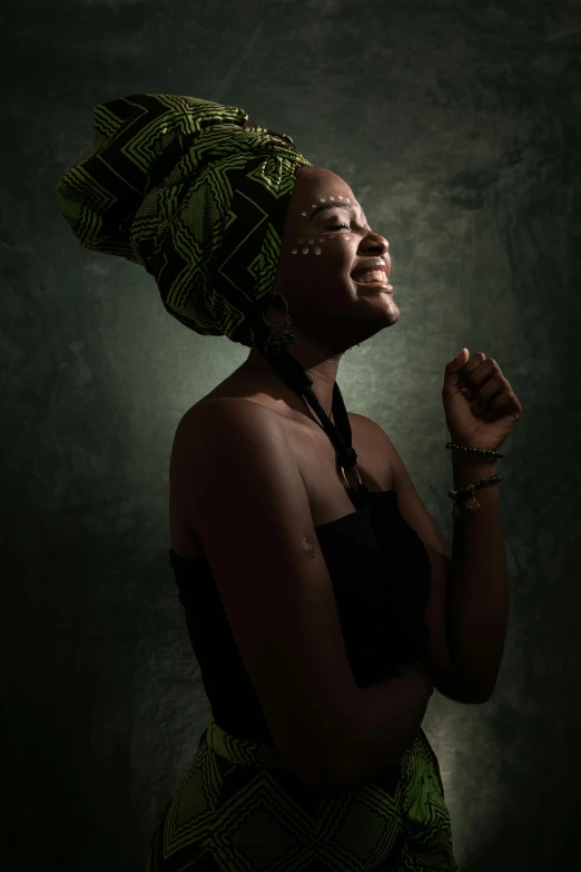 a woman with a turban on her head, an album cover, by Chinwe Chukwuogo-Roy, pexels contest winner, dramatic backlight, praying, dramatic smiling pose, medium format. soft light