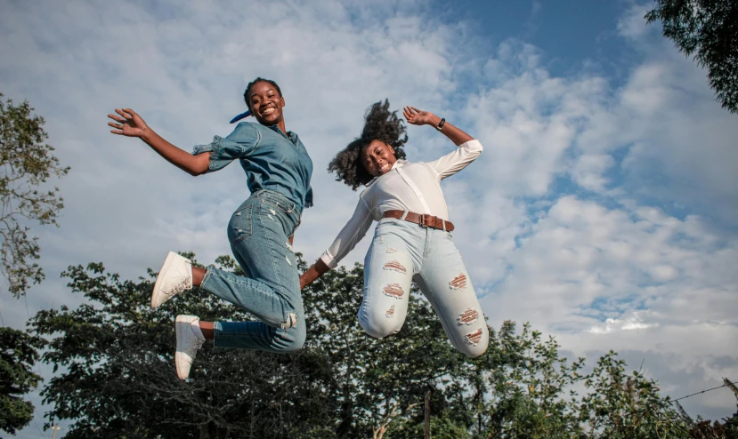 a couple of people that are jumping in the air, by Matija Jama, pexels contest winner, high school girls, avatar image, unmistakably kenyan, double denim