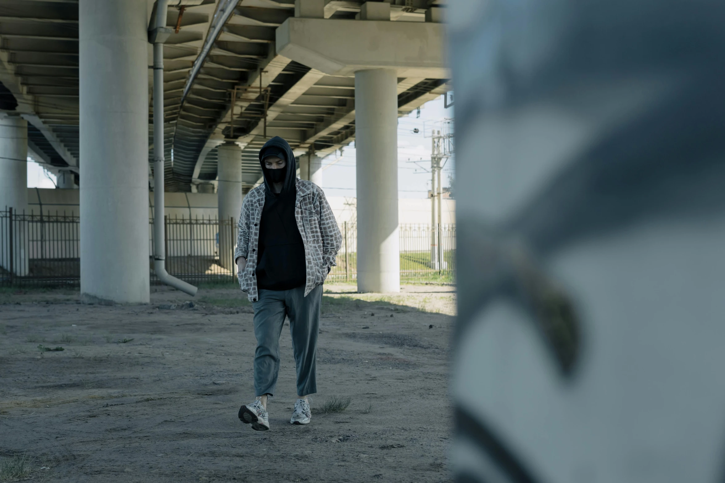 a man in a gas mask walking under a bridge, a picture, unsplash, graffiti, cinematic outfit photo, clothed in hooded, full body 8k, cinestill!!