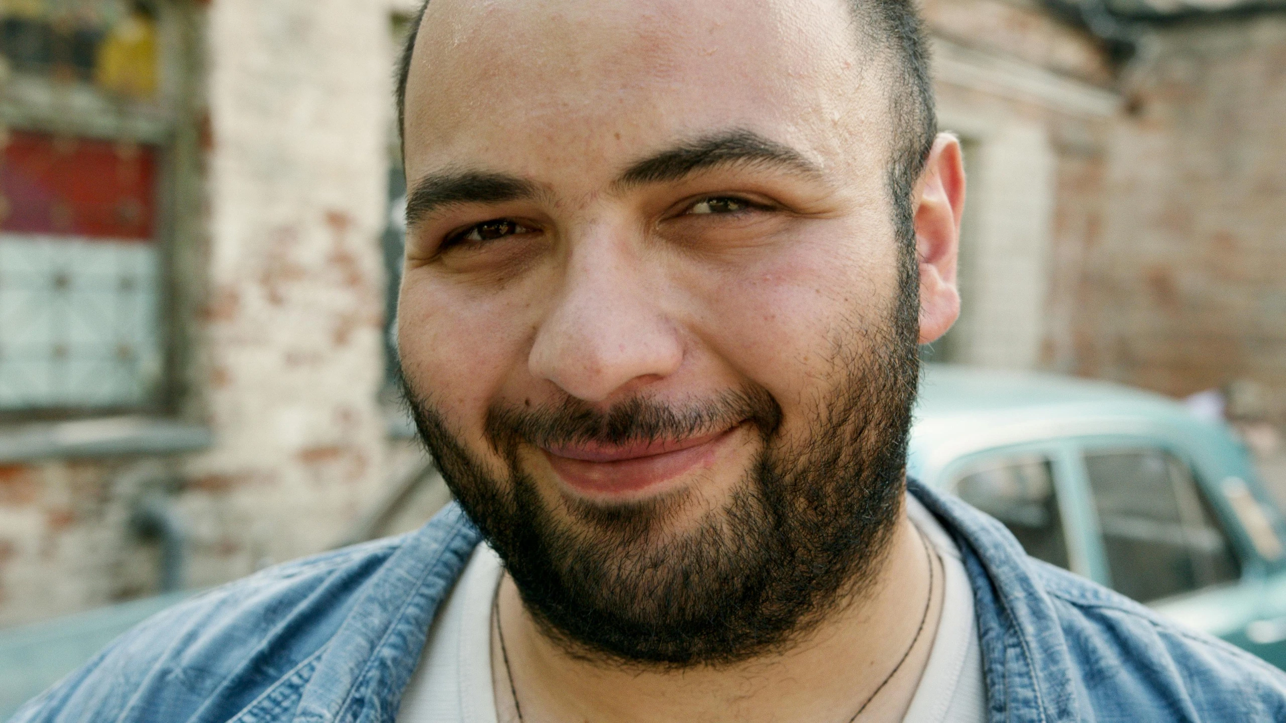 a man with a beard smiles at the camera, inspired by Nabil Kanso, plus-sized, looking away from camera, hziulquoigmnzhah, gaspar noe