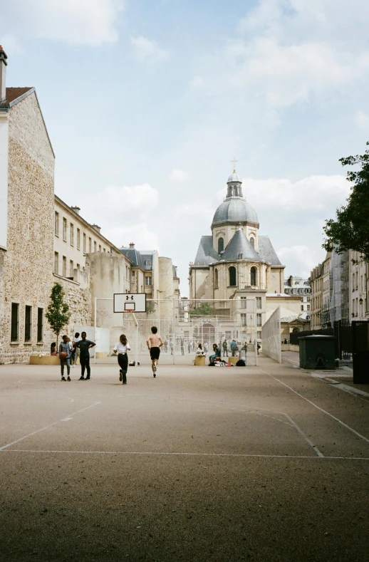 a group of people standing on top of a basketball court, an album cover, unsplash, paris school, empty streetscapes, cathedral, julia hetta, walking to the right