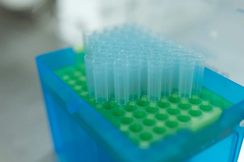a close up of a plastic container with toothbrushes in it, a microscopic photo, unsplash, pathology sample test tubes, blue and green colours, sitting on a lab table, hundreds of them
