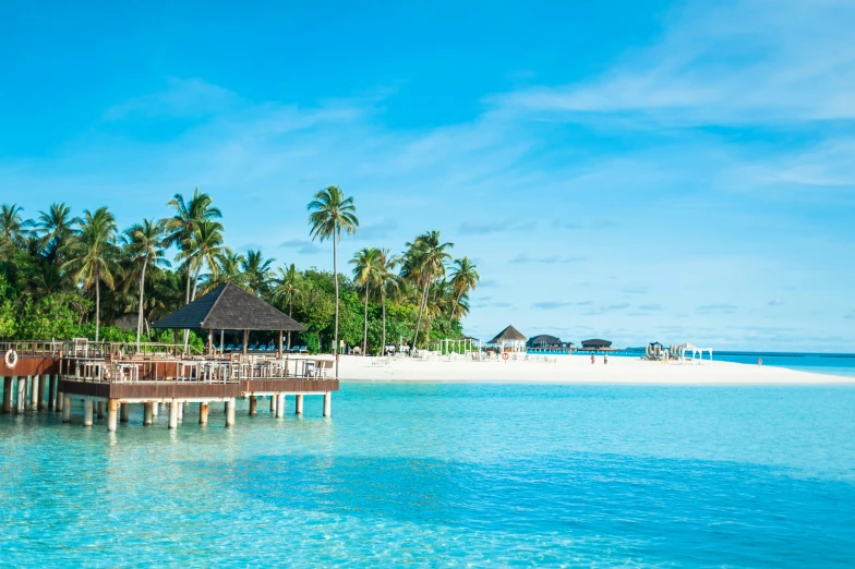 a large body of water next to a sandy beach, hurufiyya, fan favorite, huts, crystal clear blue water, profile image