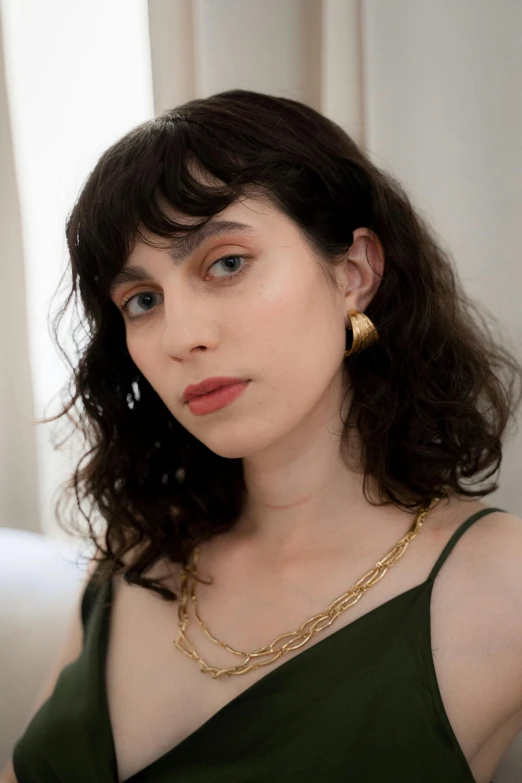 a woman in a green dress posing for a picture, gold earring, rebecca sugar, curated collection, wearing gold chain