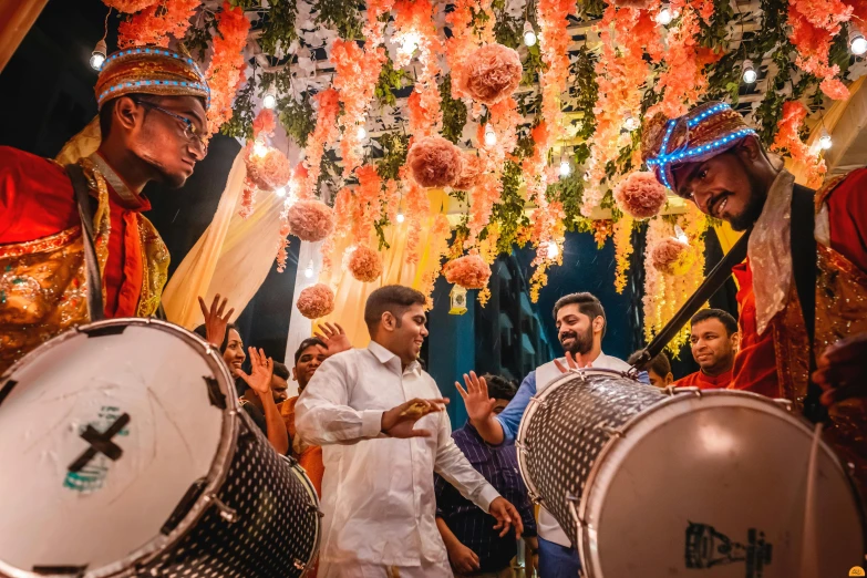 a group of men standing next to each other holding drums, by Julia Pishtar, pexels contest winner, flower decorations, vinayak, avatar image