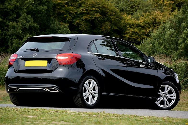 a black car parked on the side of a road, rear facing, mercedez benz, right hand side profile, thumbnail