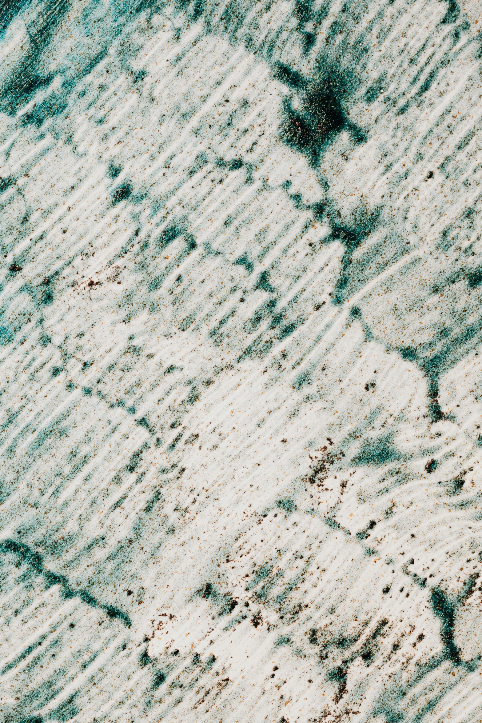 a man riding a snowboard down a snow covered slope, a microscopic photo, unsplash, lyrical abstraction, weathered concrete, glistening seafoam, close up 1 9 9 0, subtle pattern