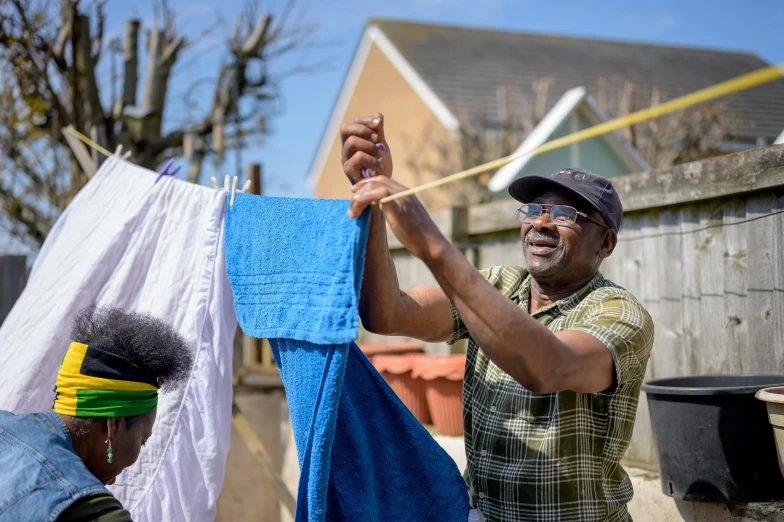 two men hanging out towels on a clothes line, a portrait, pexels contest winner, black man with afro hair, gardening, an oldman, 15081959 21121991 01012000 4k