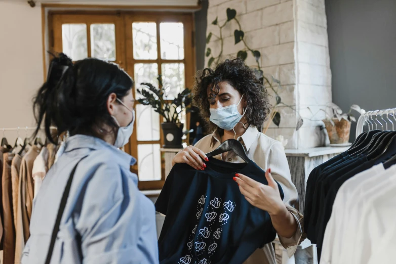 a woman wearing a face mask in a clothing store, pexels contest winner, happening, giving gifts to people, avatar image, bag, black